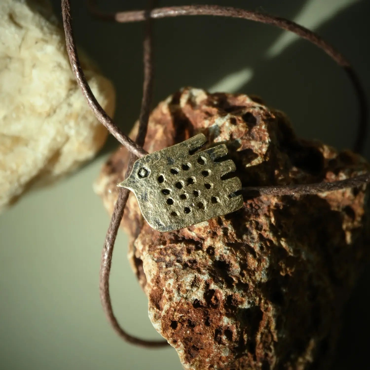 bird and hand necklace made of bronze
